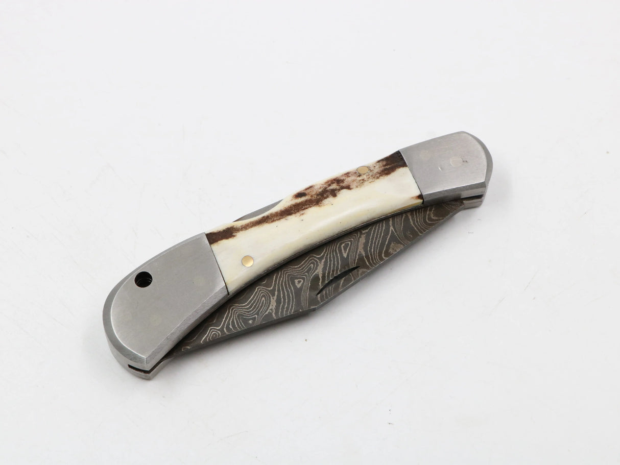 Zusammengeklapptes Taschenmesser Messerfieber Hirschkralle – kompakte Form vor hellem Hintergrund