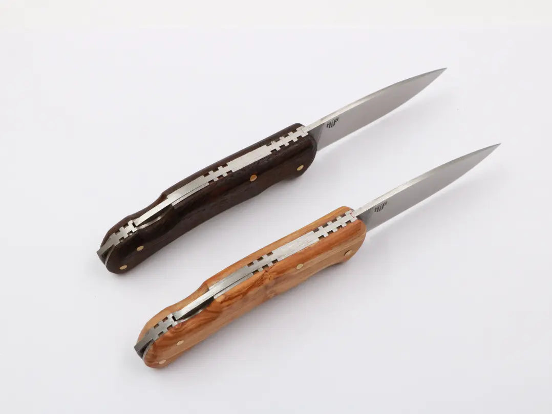 „Zwei MF Little Uiguren Slipjoint-Messer mit Holzgriff – einmal in dunklem, einmal in hellem Holz. Elegante Handarbeit mit klassischer Klinge.