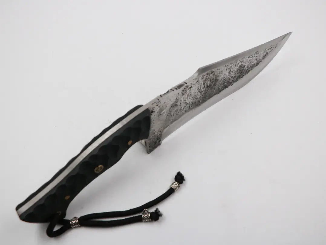 Seitenansicht der Klingenspitze mit Fokus auf Form und Materialstärke des Kambur Werkzeugs, freigestellt.