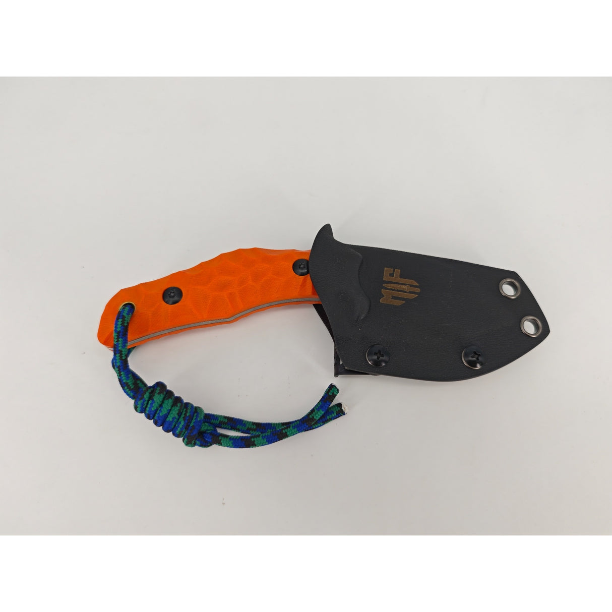 T Rex Kralle mit orangem G10-Griff und montierter Kydex-Scheide in Nahaufnahme