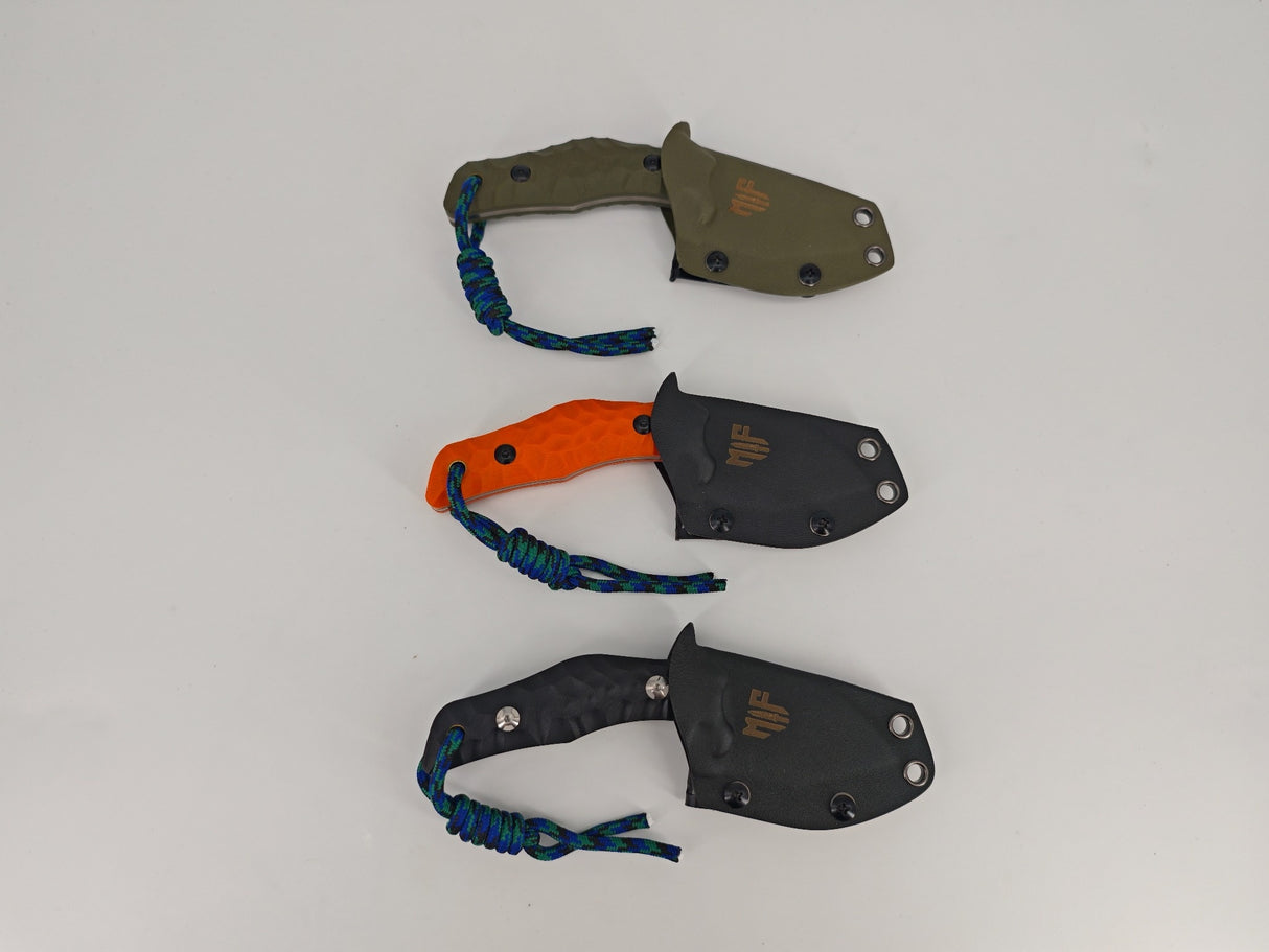 Drei Farbvarianten der T Rex Kralle – Schwarz, Orange und Olive nebeneinander