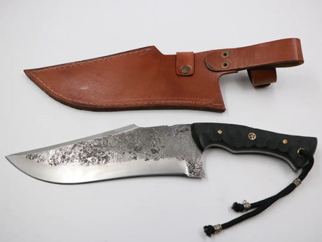 Messerfieber Kambur und die zugehörige Lederscheide nebeneinander arrangiert auf weißem Hintergrund.

