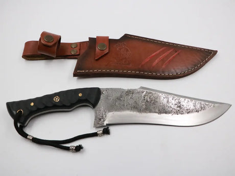 Seitenansicht des Messerfieber Kambur mit passender Lederscheide, funktionale Studioaufnahme mit neutralem Hintergrund.

