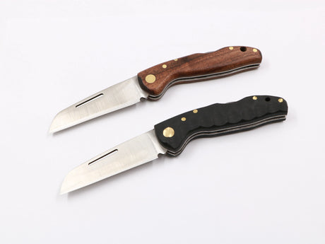 Klappermatrose Messer, beide Griffvarianten (Walnuss & T10) nebeneinander präsentiert